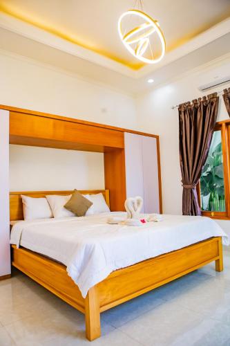 a bedroom with a large bed with white sheets at Villa Sutra Lovina in Singaraja