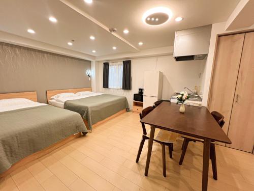 a hotel room with two beds and a table at RUKA guest house in Osaka