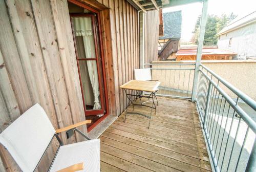 un balcone con due sedie e un tavolo di Auszeithof Niederfrohna a Niederfrohna
