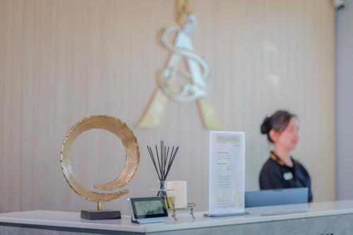 a woman standing behind a counter with a mirror at อนันตระปุระ รีสอร์ท บึงโขงหลง Anantara Pura Resort Bueng Khong Long in Ban Don Klang