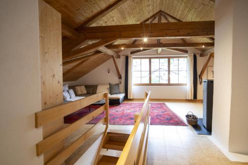 Habitación grande con techos de madera y escalera. en Ferienwohnung Scaletta, en Scuol