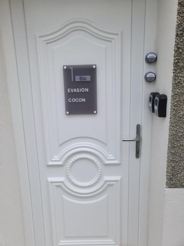 une porte blanche avec un panneau sur elle dans l'établissement Cocon, à La Souterraine