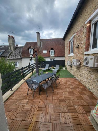 un patio avec une table et des chaises sur une terrasse dans l'établissement Cocon, à La Souterraine