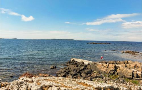 a person standing on the rocks in the ocean at 4 Bedroom Cozy Home In Torekov in Torekov