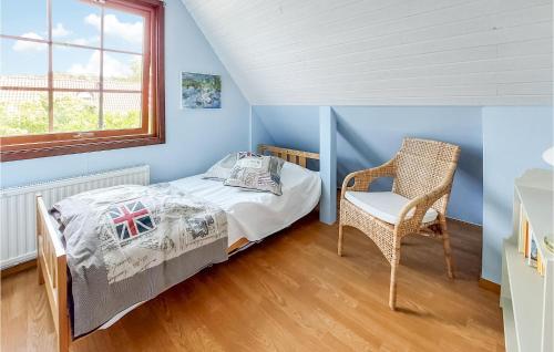 a small bedroom with a bed and a chair at 4 Bedroom Cozy Home In Torekov in Torekov