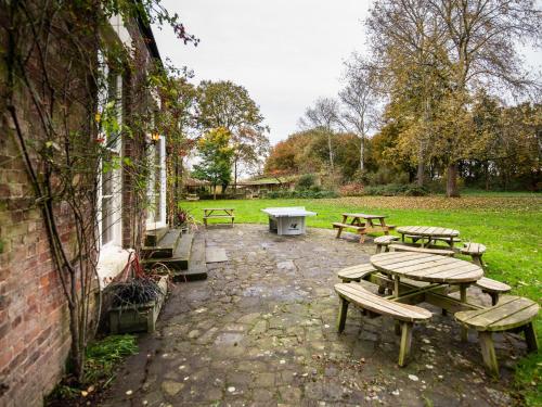 a group of picnic tables and benches in a park at YHA Chester Trafford Hall in Dunham on the Hill