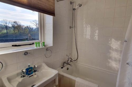 a bathroom with a tub and a sink and a shower at Willow Cottage, Youlgrave in Youlgreave