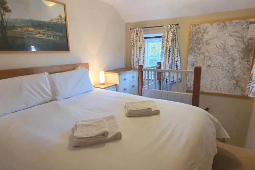 a bedroom with a white bed with two towels on it at Willow Cottage, Youlgrave in Youlgreave