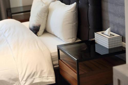 a bed with white pillows and a table with a night stand at 漫漫日出海景民宿 證號2094 in Hualien City