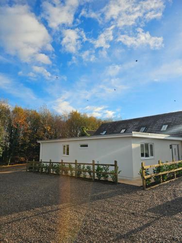 a white building with a fence in front of it at Newditch Farm - BRS Airport in Bristol