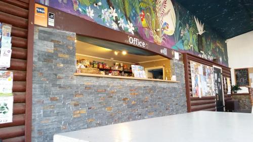 a counter in a restaurant with a brick wall at Ahipara Holiday Park in Ahipara