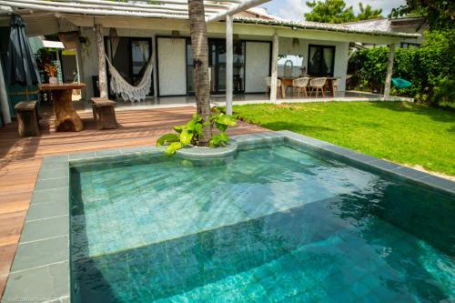 una piscina con una palma accanto a una casa di Pipa Sunset Home a Pipa
