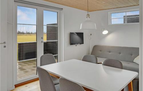 a dining room with a white table and chairs and a tv at Nice Apartment In Væggerløse With Wifi in Marielyst
