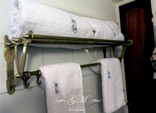 a group of towels on a towel rack in a bathroom at GM Rooms Boutique Hotel in La Rioja