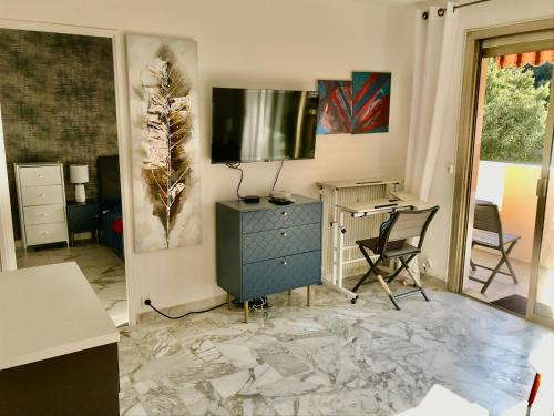 - un salon avec une télévision, une commode et un bureau dans l'établissement T2 Vallombrosa Terrasse Parking, à Cannes