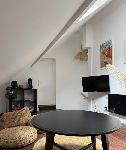 a living room with a table and a couch at VILLA LA PLAGE in Trouville-sur-Mer