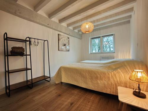 une chambre avec un lit, une table et une lampe dans l'établissement Charmante maison de campagne avec cheminée, à Souligné-Flacé