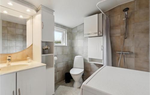 a white bathroom with a toilet and a sink at 2 Bedroom Cozy Home In Nyborg in Nyborg