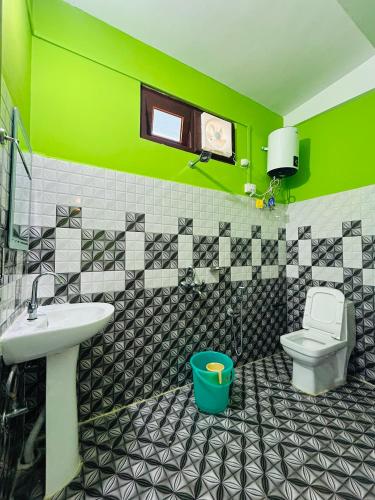 a green bathroom with a sink and a toilet at Kalden Homestay in Dirang Dzong