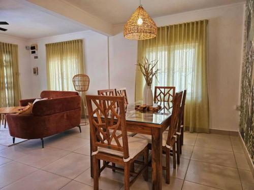 a living room with a table and chairs and a couch at Villa Ti CoCo Elegant Tropical Villa with Pool and Terraces in Trou aux Biches