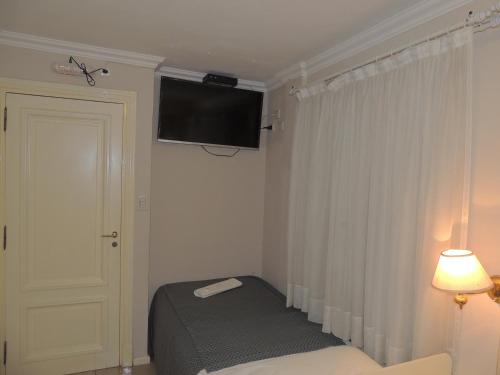 una camera da letto con un letto e una televisione a parete di GM Rooms Rental Suites a La Rioja