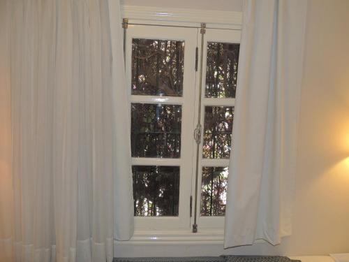 a window with white curtains in a room at GM Rooms Boutique Hotel in La Rioja