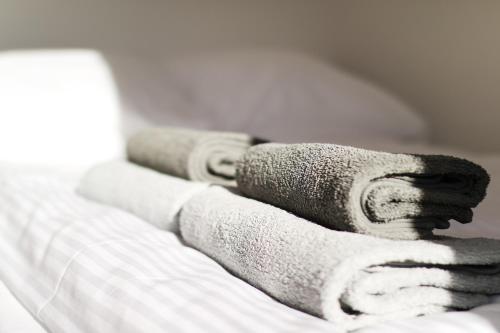 a pile of towels sitting on top of a bed at Willa VITA Muszyna - rodzinne apartamenty blisko natury i atrakcji - 15min pieszo do centrum - 15min autem do stoku in Muszyna