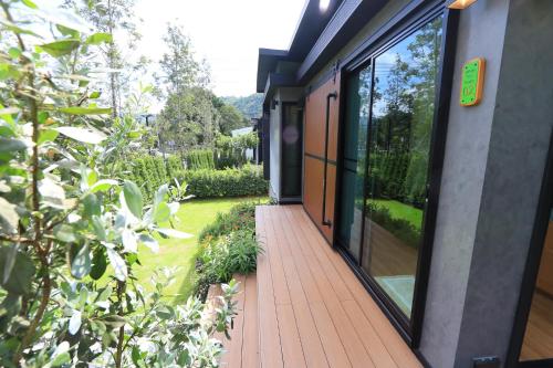 a porch of a house with large glass windows at Willow Tree House Khao Yai in Mu Si