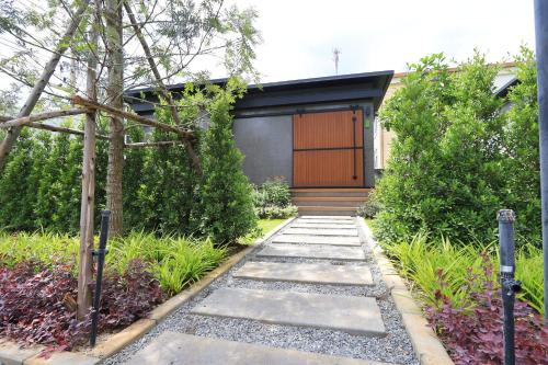 a walkway leading to the front door of a house at Willow Tree House Khao Yai in Mu Si