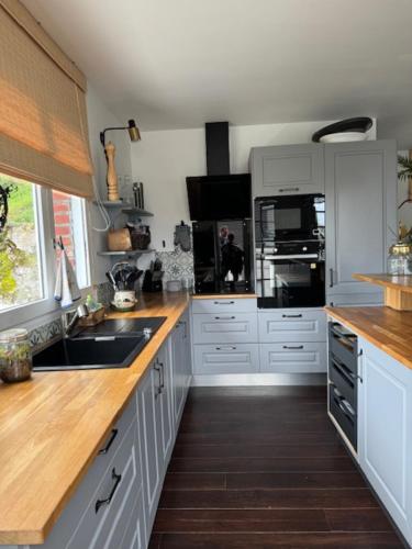 a kitchen with white cabinets and a wooden floor at VILLA LA PLAGE in Trouville-sur-Mer