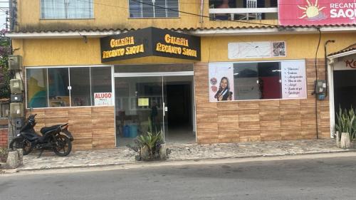 a store with a motorcycle parked in front of it at Hostel Recanto in Saquarema