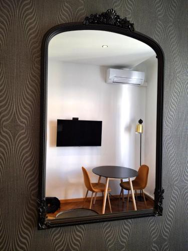 un miroir reflétant une table et des chaises dans la chambre dans l'établissement Superbe Appartement au Cœur de Nice, à Nice
