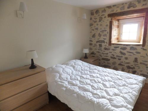 a bedroom with a white bed and a window at Le Relais d'Anglards in Anglards-de-Saint-Flour