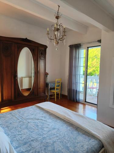 - une chambre avec un lit, un miroir et un lustre dans l'établissement Coqueto Apartamento en Hendaya, à Hendaye