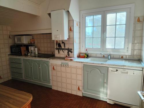 - une cuisine avec des placards verts et un lave-vaisselle blanc dans l'établissement Coqueto Apartamento en Hendaya, à Hendaye