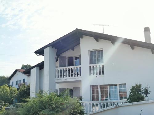 a white house with a balcony at Coqueto Apartamento en Hendaya in Hendaye
