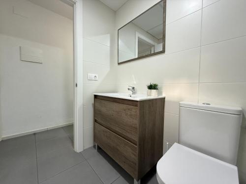 une salle de bain avec un lavabo, des toilettes et un miroir dans l'établissement Agi Peater Center, à Roses