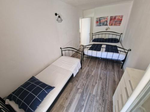 two beds in a small room with wooden floors at Apartments Arboreum in Ivan Dolac
