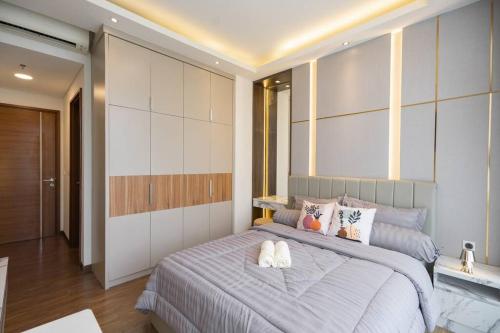 a bedroom with a bed with two pillows on it at 2BR Luxury Condo with 10Ha garden di Marigold BSD in Lengkong-kulon