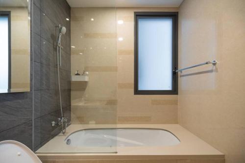 a bath tub in a bathroom with a window at 2BR Luxury Condo with 10Ha garden di Marigold BSD in Lengkong-kulon