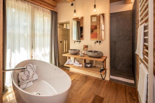 a bathroom with two sinks and a bath tub at Valsegg Chalets Südtirol - luxury and private hideaway in Valles