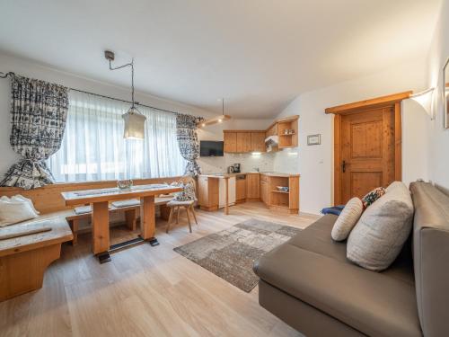 Una sala de estar con un sofá y una mesa y una cocina. en Alt Poschach, en Obergurgl