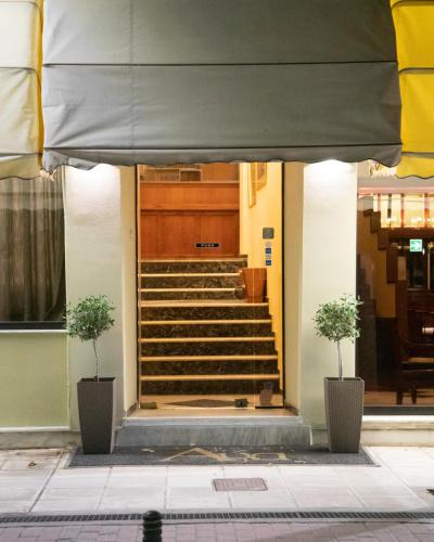 a stairway with two plants in front of a building at Hotel Avra in Kardítsa