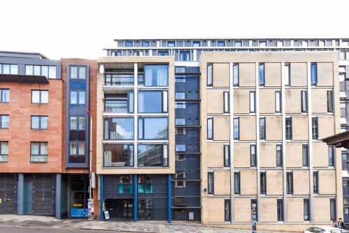 an apartment building with many windows on a street at Ensuites in Portsburgh Court Edinburgh in Edinburgh