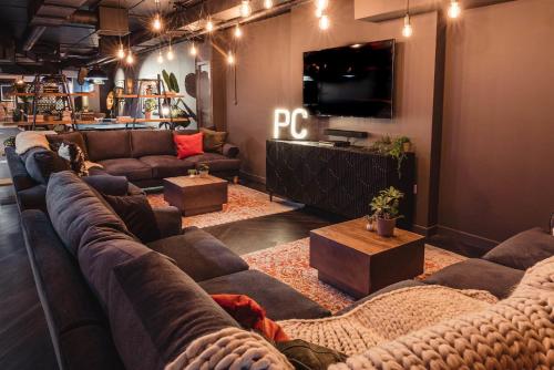 a living room with couches and a flat screen tv at Ensuites in Portsburgh Court Edinburgh in Edinburgh