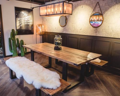 a wooden table with a bench and a table with a white rug at Ensuites in Portsburgh Court Edinburgh in Edinburgh