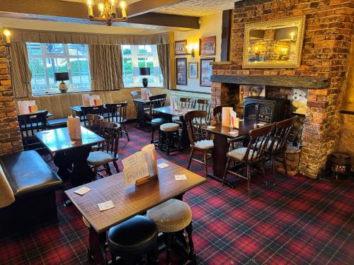 a restaurant with tables and chairs and a fireplace at New Masons Arms in Leeds
