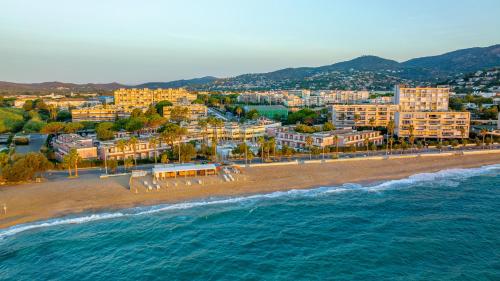 an aerial view of a beach with buildings and the ocean at Résidence Kaliopé in Le Lavandou