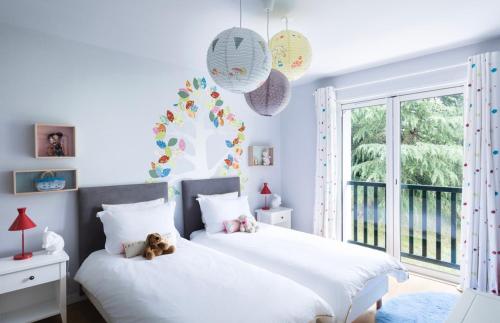 Deux lits dans une chambre avec un ours en peluche assis sur eux dans l'établissement Villa Souraide, à Souraïde