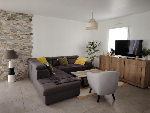 ein Wohnzimmer mit Sofa und Fernseher in der Unterkunft location bord de mer La Plaine sur mer in La Plaine-sur-Mer